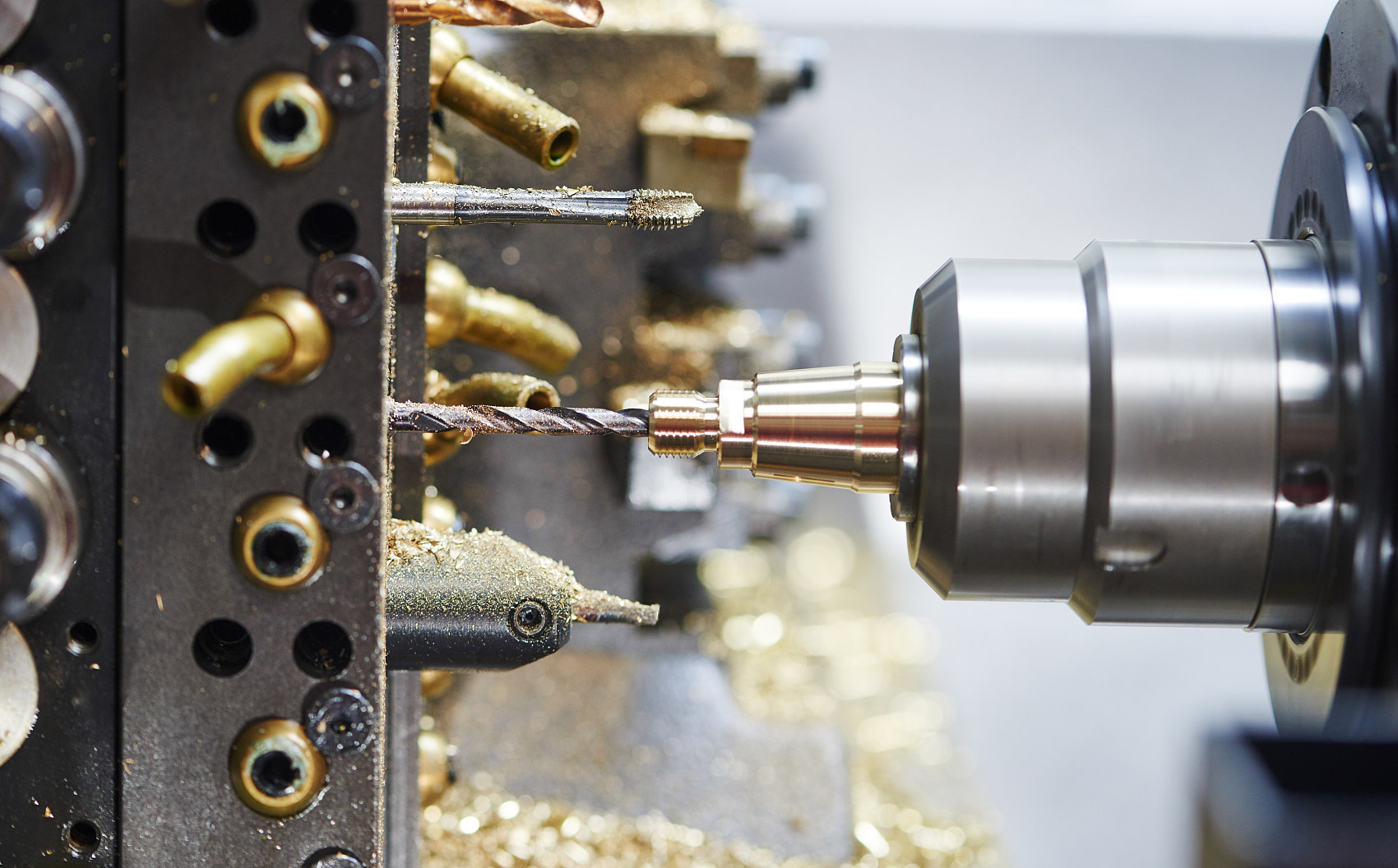 High-precision CNC Swiss-type lathe performing multi-axis drilling and tapping on an intricate turned component — demonstrating tight-tolerance, single-chucking machining for aerospace and medical parts.