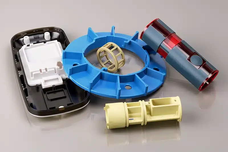 Custom multi-color injection molded plastic consumer electronics components including device housings enclosures impeller rings and cylindrical parts — precision plastic mold manufacturing for OEM product lines