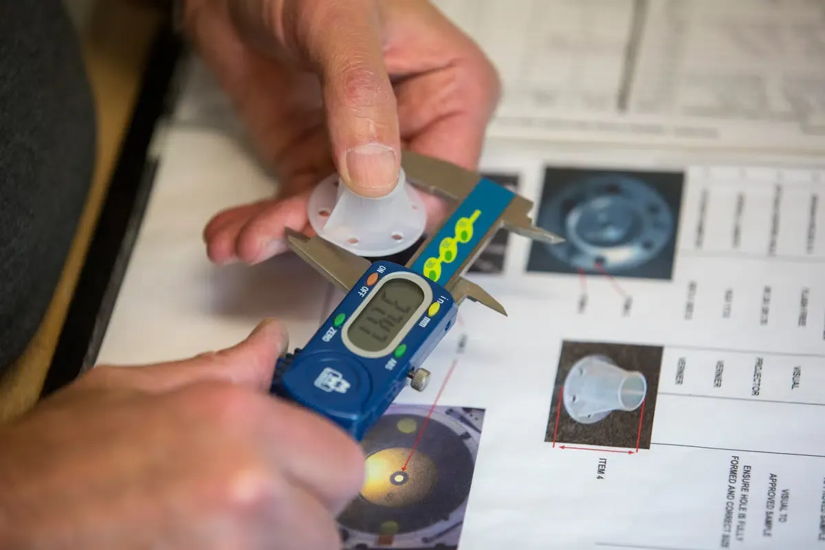 In-process dimensional accuracy inspection of injection molded plastic component using digital caliper referenced against GD&T engineering drawing and control plan — first article inspection FAI and in-process quality control for custom precision injection molded parts