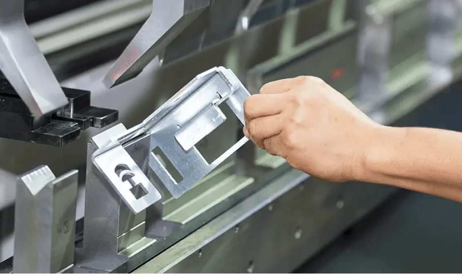 CNC press brake bending sheet metal part with technician adjusting position for precision accuracy